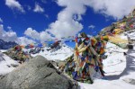 Prayer flags and scarves left by grateful passers by.